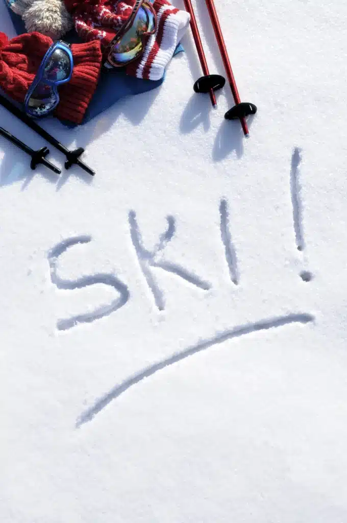 Matériel de ski posé sur la neige avec ski écrit en grand sur la neige